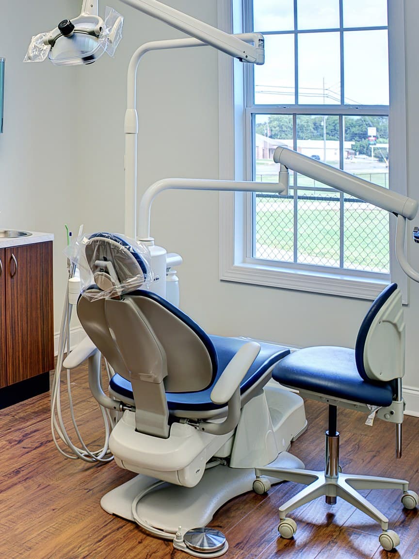 An empty dental operatory, the chair facing a window